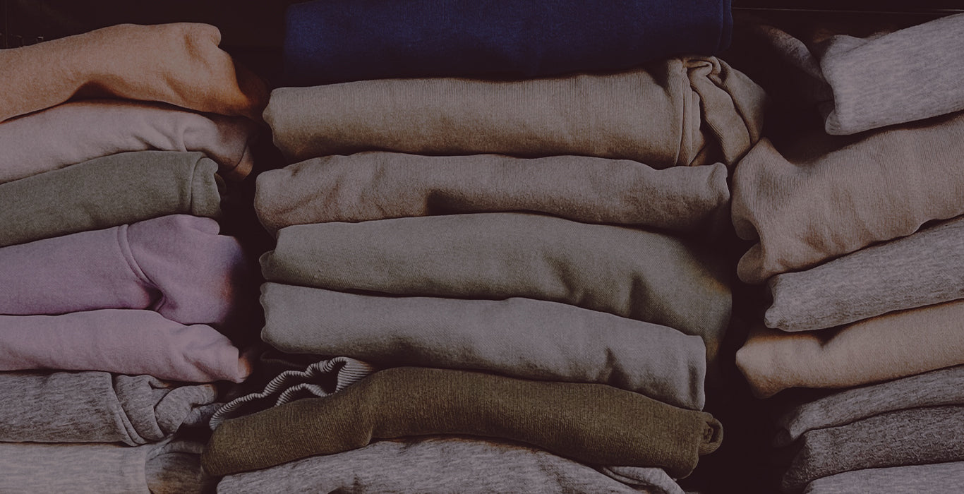 Stack of folded clothes in various colors on a dark background
