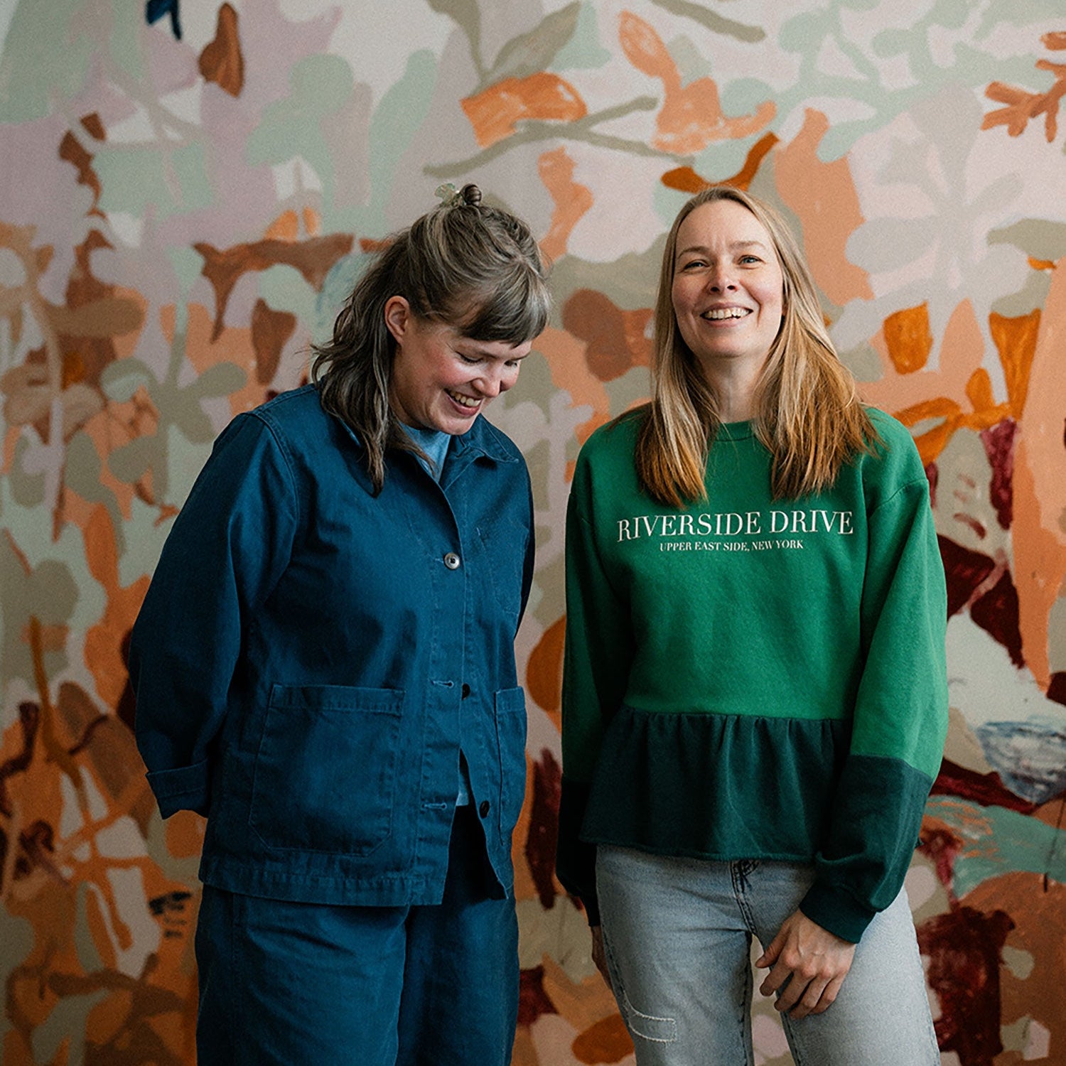 Ulrika and Hanna standing in front of a colorful mural.